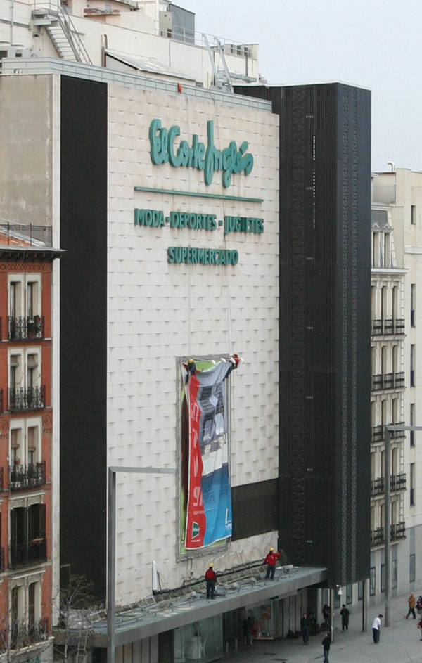 workers rapelling down the side of El Corte Inglés to change the sign